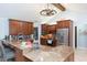 Open kitchen featuring wood cabinetry, granite countertops, stainless appliances, and decorative hanging lighting at 2709 Fairway View Dr, Valrico, FL 33596