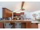 An open kitchen is shown with wood cabinets, granite counters, stainless appliances, and breakfast bar seating at 2709 Fairway View Dr, Valrico, FL 33596