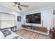 Cozy living room features a ceiling fan, floating wood entertainment center, and ample natural light at 2709 Fairway View Dr, Valrico, FL 33596