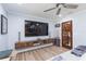 The living room boasts a rustic floating entertainment center and a view of the cozy, wooden-doored entry to another room at 2709 Fairway View Dr, Valrico, FL 33596