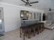 This outdoor bar area features comfortable seating, a ceiling fan, and lots of space to entertain at 2709 Fairway View Dr, Valrico, FL 33596