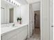 Bathroom featuring a white vanity with a mirror, sink, and decorative flowers at 325 Madeira Cir, Tierra Verde, FL 33715
