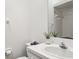 Bright bathroom with a white sink, mirror, decorative vase, and tiled walls at 325 Madeira Cir, Tierra Verde, FL 33715