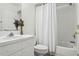 Bright bathroom features a white vanity, toilet, and shower with white curtain at 325 Madeira Cir, Tierra Verde, FL 33715
