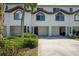 Townhouse exterior features garages, arched windows, and lush landscaping for added curb appeal at 325 Madeira Cir, Tierra Verde, FL 33715