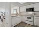Well-lit kitchen with white appliances and cabinetry, offering functionality and a clean aesthetic at 325 Madeira Cir, Tierra Verde, FL 33715