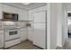 Functional kitchen with white appliances and ample cabinet space, ideal for everyday cooking at 325 Madeira Cir, Tierra Verde, FL 33715