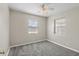 Bedroom featuring neutral walls, gray carpeting, a ceiling fan, and natural light from two windows at 350 51St N Ave, St Petersburg, FL 33703