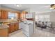 This kitchen features wood cabinets and white appliances and offers a view to the living room at 350 51St N Ave, St Petersburg, FL 33703