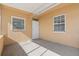 A sunroom features light peach walls, windows, concrete flooring and a back door at 350 51St N Ave, St Petersburg, FL 33703