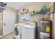 Functional laundry area with washer, dryer, water heater, shelving, and exterior door for added convenience at 5426 6Th Avenue N, St Petersburg, FL 33710