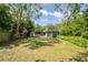 Expansive backyard with lush greenery, wooden deck, and shed, creating a peaceful outdoor space at 5915 N Otis Ave, Tampa, FL 33604
