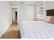 Well-lit bedroom with wood flooring, and a glimpse into the hallway and other rooms at 5915 N Otis Ave, Tampa, FL 33604