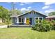 Charming blue bungalow with a bright yellow front door and a cozy front porch at 5915 N Otis Ave, Tampa, FL 33604