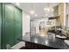 Kitchen featuring green cabinets, stainless steel appliances, and a brick accent wall at 5915 N Otis Ave, Tampa, FL 33604