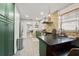 Spacious kitchen with an island, green cabinetry, stainless steel appliances, and brick accent wall at 5915 N Otis Ave, Tampa, FL 33604