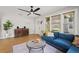 Spacious living room with a blue sectional, wood floors, and bright windows at 5915 N Otis Ave, Tampa, FL 33604