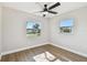 Bright bedroom featuring wood-look flooring, dual windows, and a ceiling fan at 6434 Sawyer Rd, Tampa, FL 33634