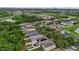 Wide aerial perspective displaying a residential neighborhood with lush trees and solar panels on select homes at 7842 Carriage Pointe Dr, Gibsonton, FL 33534