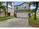 Daytime view of a gray two-story home featuring a well-maintained lawn and a two-car garage at 7842 Carriage Pointe Dr, Gibsonton, FL 33534
