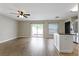Open-concept living room with fan, a sliding glass door to outside, and a view of the kitchen at 7842 Carriage Pointe Dr, Gibsonton, FL 33534