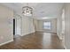 Open-concept living space with modern lighting, wood floors, and lots of natural light at 7842 Carriage Pointe Dr, Gibsonton, FL 33534