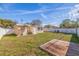 Large, fenced backyard with green grass, a small deck, and a patio seating area, perfect for outdoor enjoyment and relaxation at 8792 93Rd St, Seminole, FL 33777