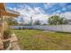 Spacious backyard with a lush green lawn, a white fence, and a cozy seating area, ideal for relaxing and enjoying the outdoors at 8792 93Rd St, Seminole, FL 33777