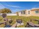A well-kept backyard with lush grass, a white fence, and cozy seating around a fire pit, perfect for outdoor gatherings at 8792 93Rd St, Seminole, FL 33777