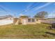 A well-maintained backyard featuring a comfortable seating arrangement on a lush green lawn, enclosed by a white fence at 8792 93Rd St, Seminole, FL 33777