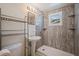 Bathroom featuring pedestal sink, gray shower with window, and storage shelving unit at 8792 93Rd St, Seminole, FL 33777