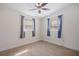 Bedroom with ceiling fan, neutral carpet, and light walls with two windows at 8792 93Rd St, Seminole, FL 33777