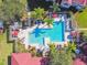 Aerial view of a community pool area surrounded by manicured landscaping and palm trees at 9481 Highland Oak Dr # 404, Tampa, FL 33647