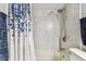 Marble-look tile shower over tub featuring brushed nickel fixtures and blue curtain at 9481 Highland Oak Dr # 404, Tampa, FL 33647