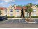 Two story tan condo building with red roof, palm trees, and reserved parking at 9481 Highland Oak Dr # 404, Tampa, FL 33647