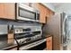 Modern kitchen with stainless steel appliances, dark countertops, and wood cabinets at 9481 Highland Oak Dr # 404, Tampa, FL 33647