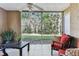 Relaxing sunroom with tile flooring, ceiling fan, and a beautiful view of the lush greenery at 9481 Highland Oak Dr # 404, Tampa, FL 33647