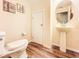 Powder room features stylish pedestal sink, modern commode, and wood-look floors at 9873 Trumpet Vine Loop, Trinity, FL 34655