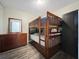 Bedroom showcasing a wooden bunk bed, dresser, and dark closet with wood-look flooring at 9873 Trumpet Vine Loop, Trinity, FL 34655