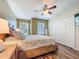 Comfortable bedroom featuring a ceiling fan, wood-look flooring, and natural light from the windows at 9873 Trumpet Vine Loop, Trinity, FL 34655