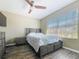 Cozy bedroom with wood-look flooring, a queen bed, and large windows with natural light at 9873 Trumpet Vine Loop, Trinity, FL 34655