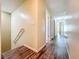 Bright hallway with wood-look flooring, neutral paint, and access to multiple rooms at 9873 Trumpet Vine Loop, Trinity, FL 34655
