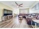 Comfortable living room with a large brown leather sectional, ceiling fan, and modern wood-look floors at 9873 Trumpet Vine Loop, Trinity, FL 34655