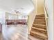 Spacious living area featuring wood stairs, a ceiling fan, and a comfortable leather sectional at 9873 Trumpet Vine Loop, Trinity, FL 34655