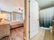An inviting main bedroom with a ceiling fan, windows for natural light, and a glimpse into the adjacent bathroom at 9873 Trumpet Vine Loop, Trinity, FL 34655