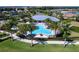 Aerial view of a community pool and clubhouse with palm trees and tropical landscaping at 809 Seascape Pl, Sarasota, FL 34240