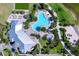 Aerial view of a community pool, clubhouse, and beach volleyball court with tropical landscaping at 809 Seascape Pl, Sarasota, FL 34240