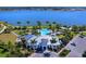 Aerial view of a community pool, clubhouse, and lake with lush tropical landscaping at 809 Seascape Pl, Sarasota, FL 34240