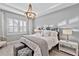 Cozy bedroom with a decorative chandelier, shuttered window, and comfortable bedding at 809 Seascape Pl, Sarasota, FL 34240