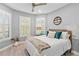 Cozy bedroom featuring shuttered windows, a ceiling fan, and a comfortable queen-sized bed at 809 Seascape Pl, Sarasota, FL 34240